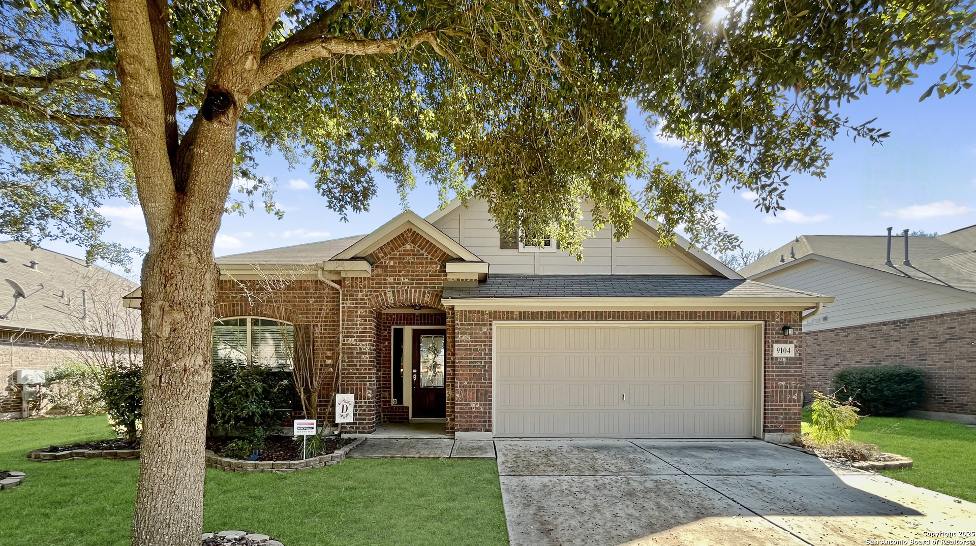 a front view of a house with a yard and an tree