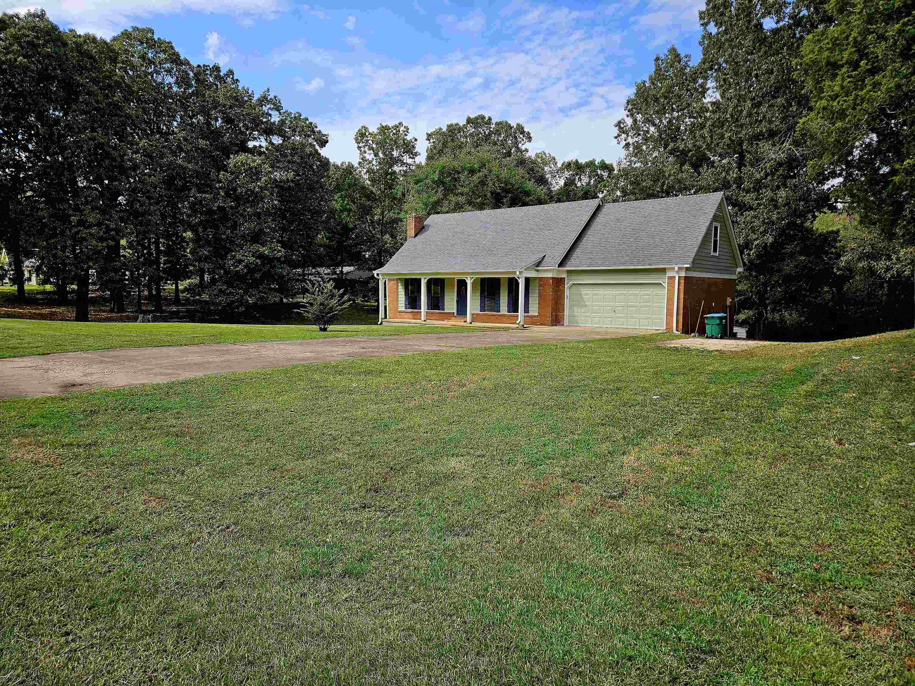 an aerial view of house with yard and trees in the background