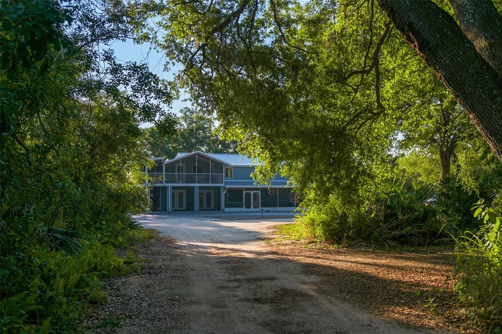 a front view of a house with a yard and trees