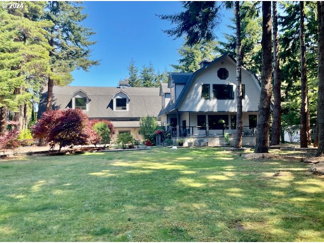 a front view of house with yard and trees in the background