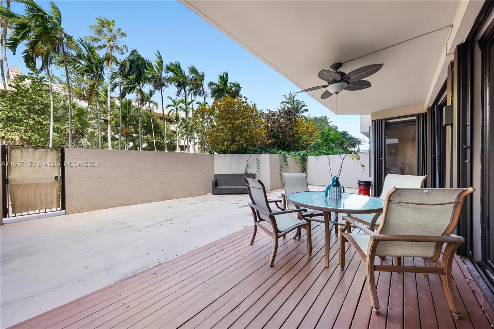 a view of a patio with table and chairs and potted plants with wooden floor