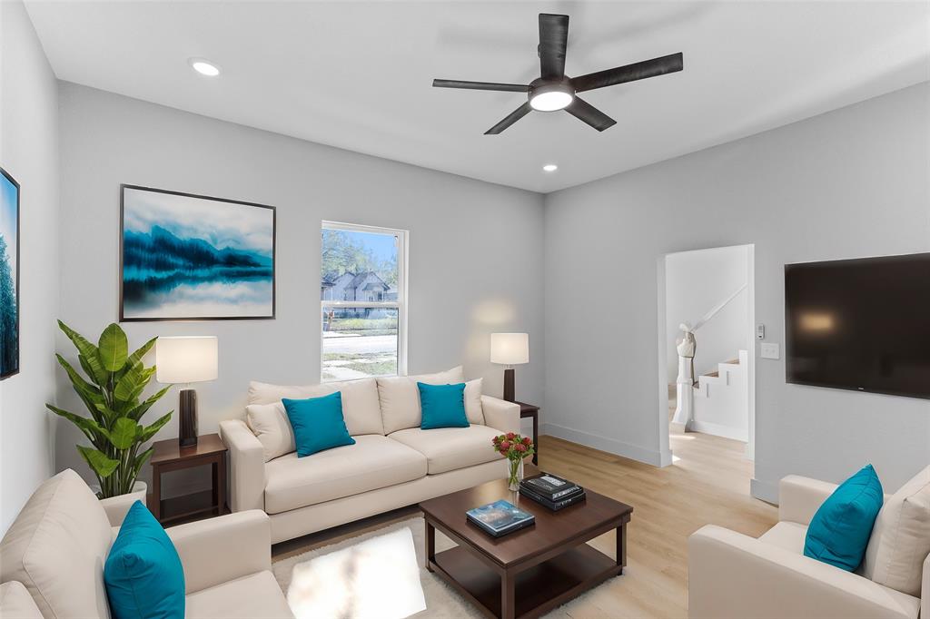 a living room with furniture a flat screen tv and potted plant