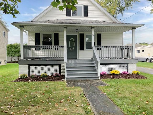 View of front of property with a front lawn and covered porch