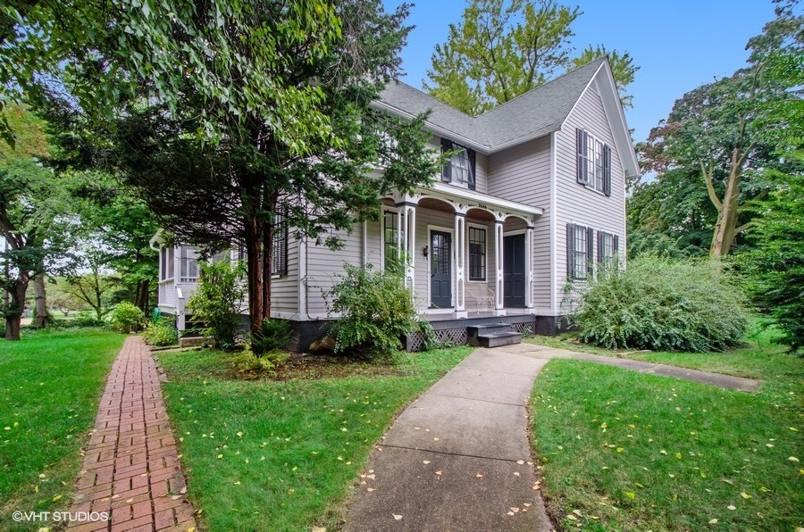 a front view of a house with a yard and potted plants