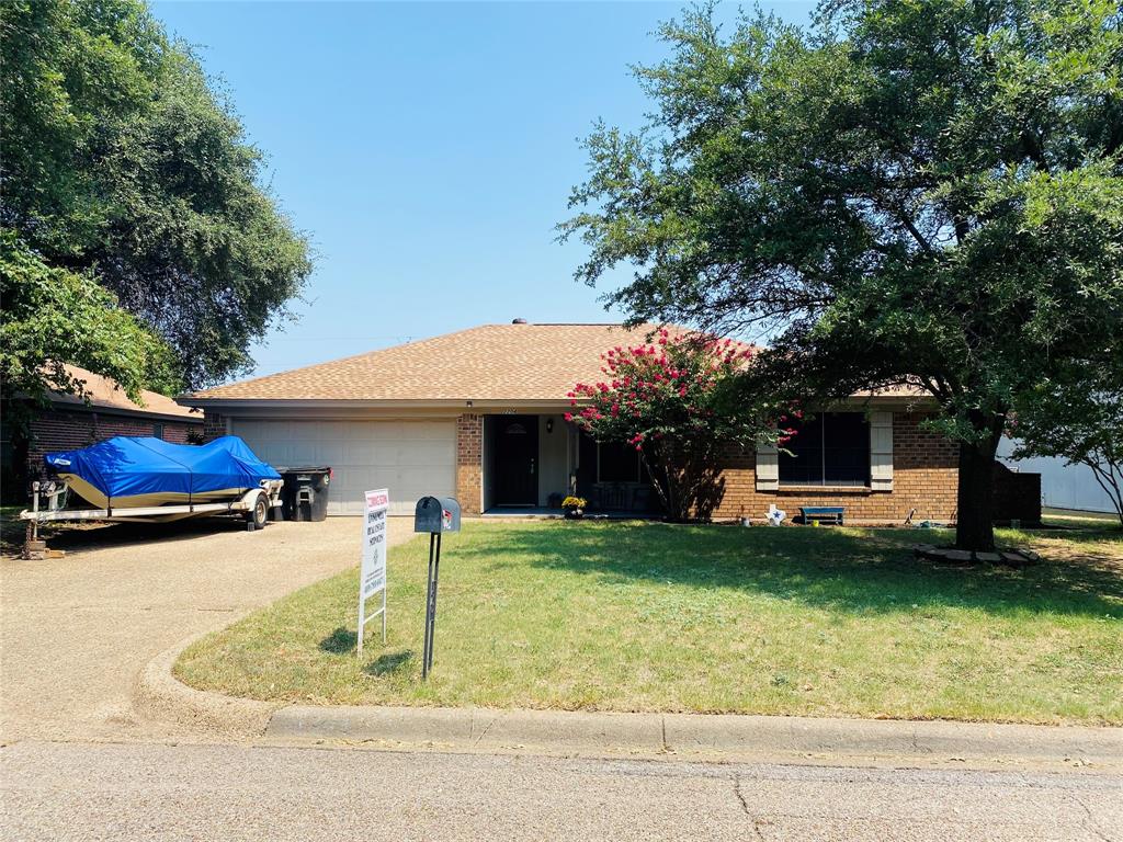 a front view of a house with a garden and trees