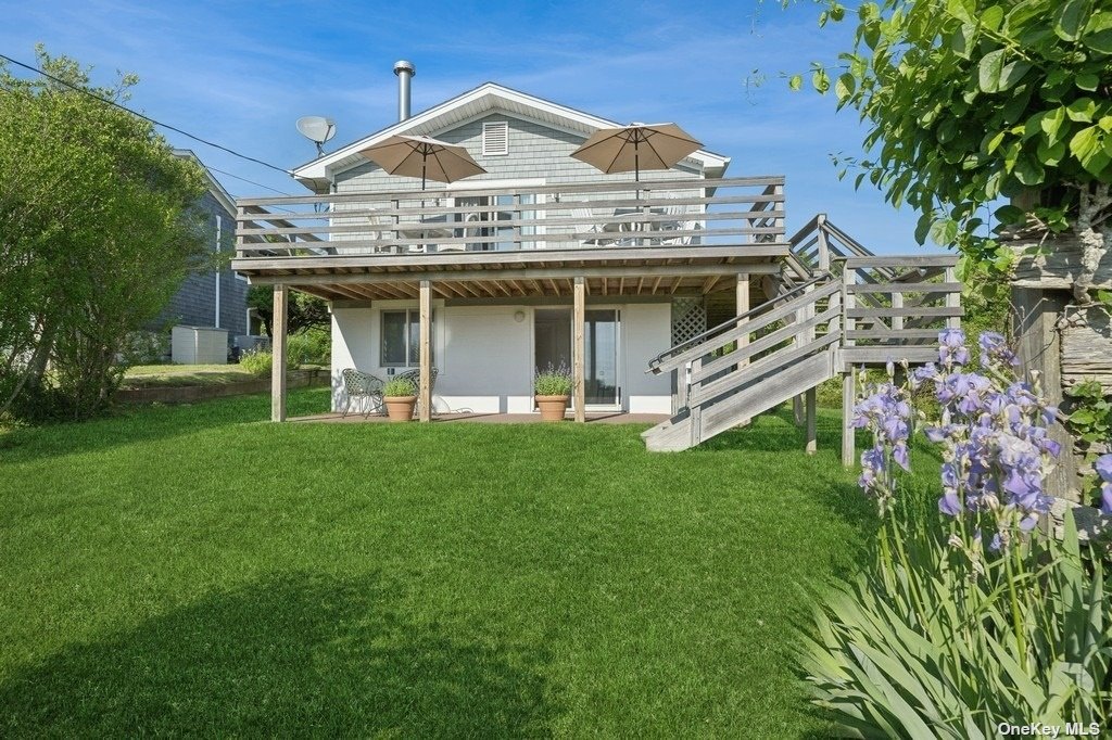 a view of a house with a big yard potted plants and large tree