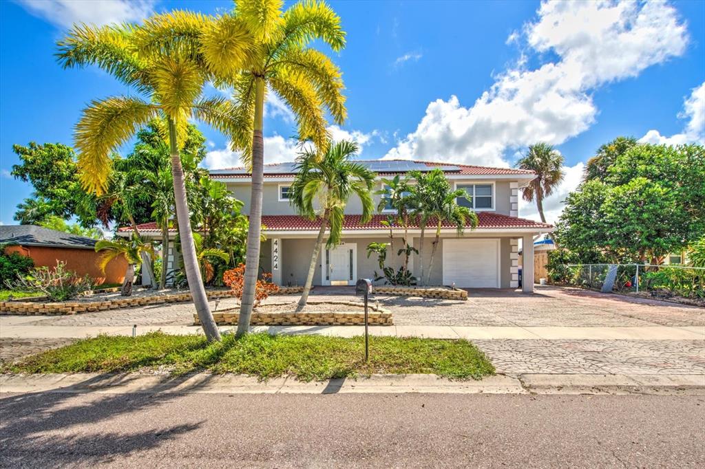 a front view of a house with a yard and potted plants