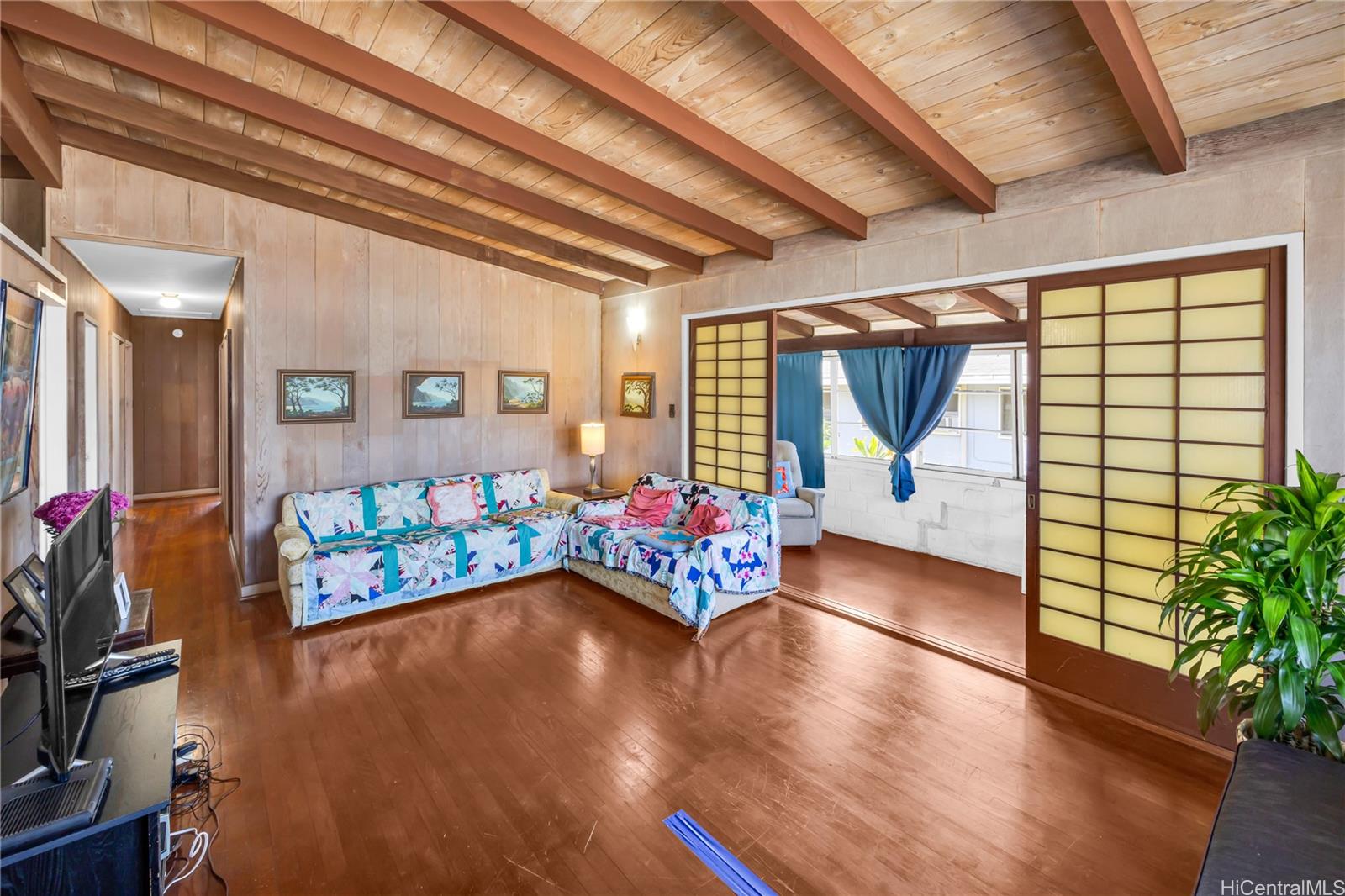 a hallway with wooden floor stairs and a couch