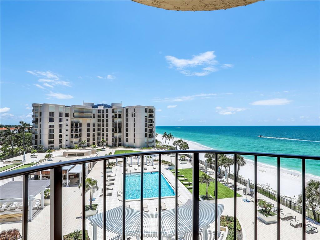 Balcony featuring a community pool, a view of the beach, and a water view