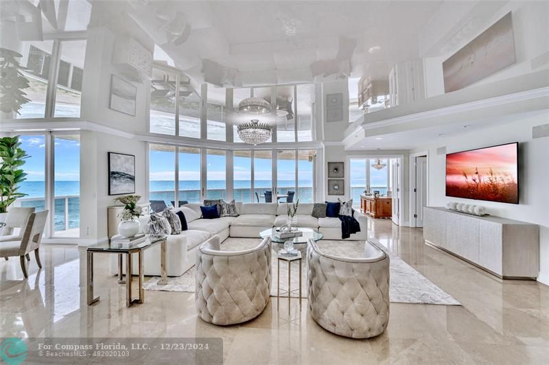 a living room with furniture a flat screen tv and a large window