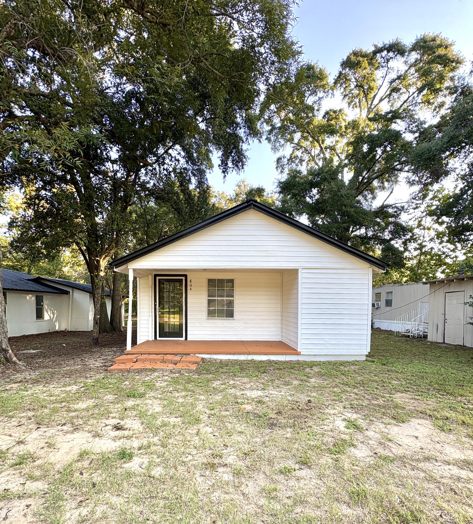 a front view of house with yard and trees around