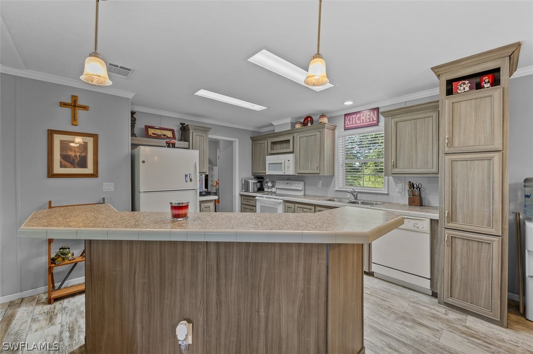 a kitchen with kitchen island a refrigerator stove and sink