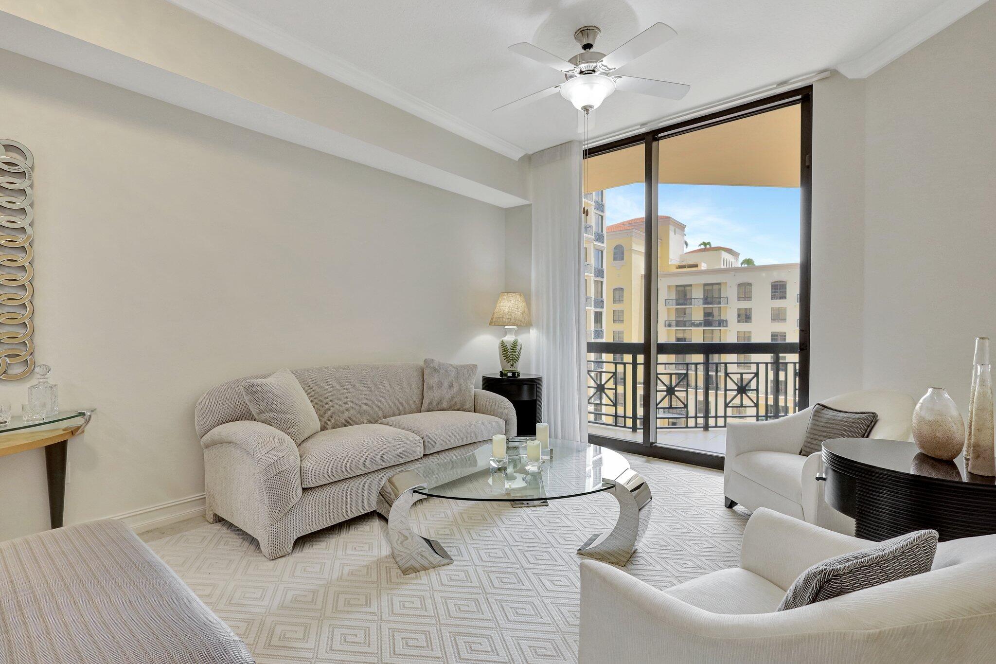 a living room with furniture and a large window with balcony view