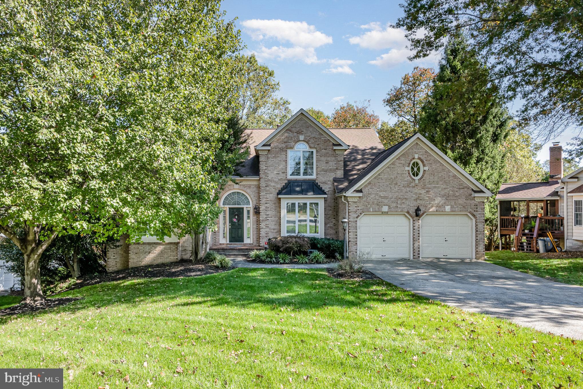 a front view of a house with a yard and trees