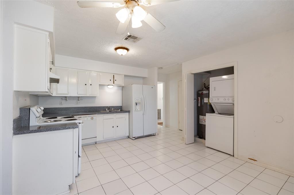 a kitchen with granite countertop white cabinets and white appliances