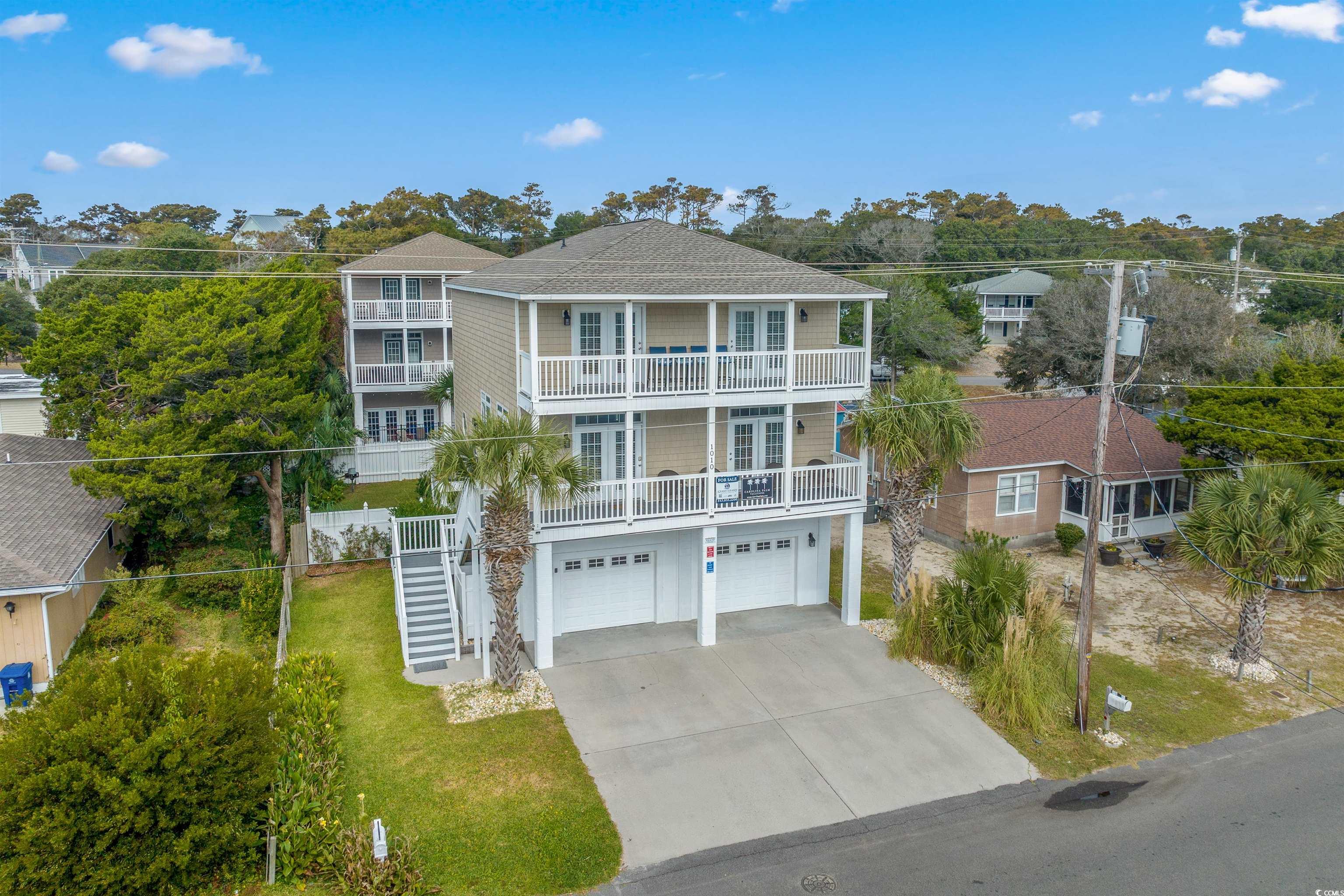 Beach home with a front yard, a garage, and a balc