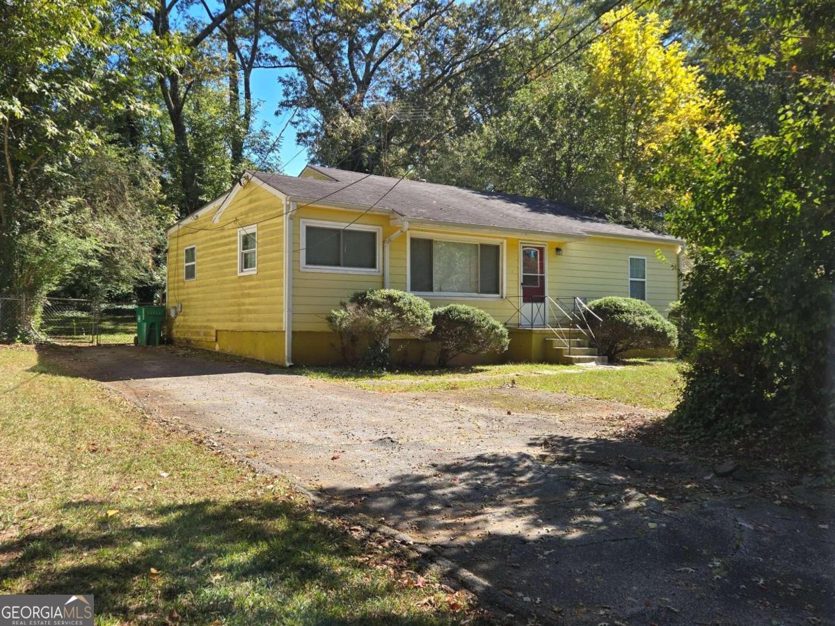 a view of a yard in front of a house with large trees