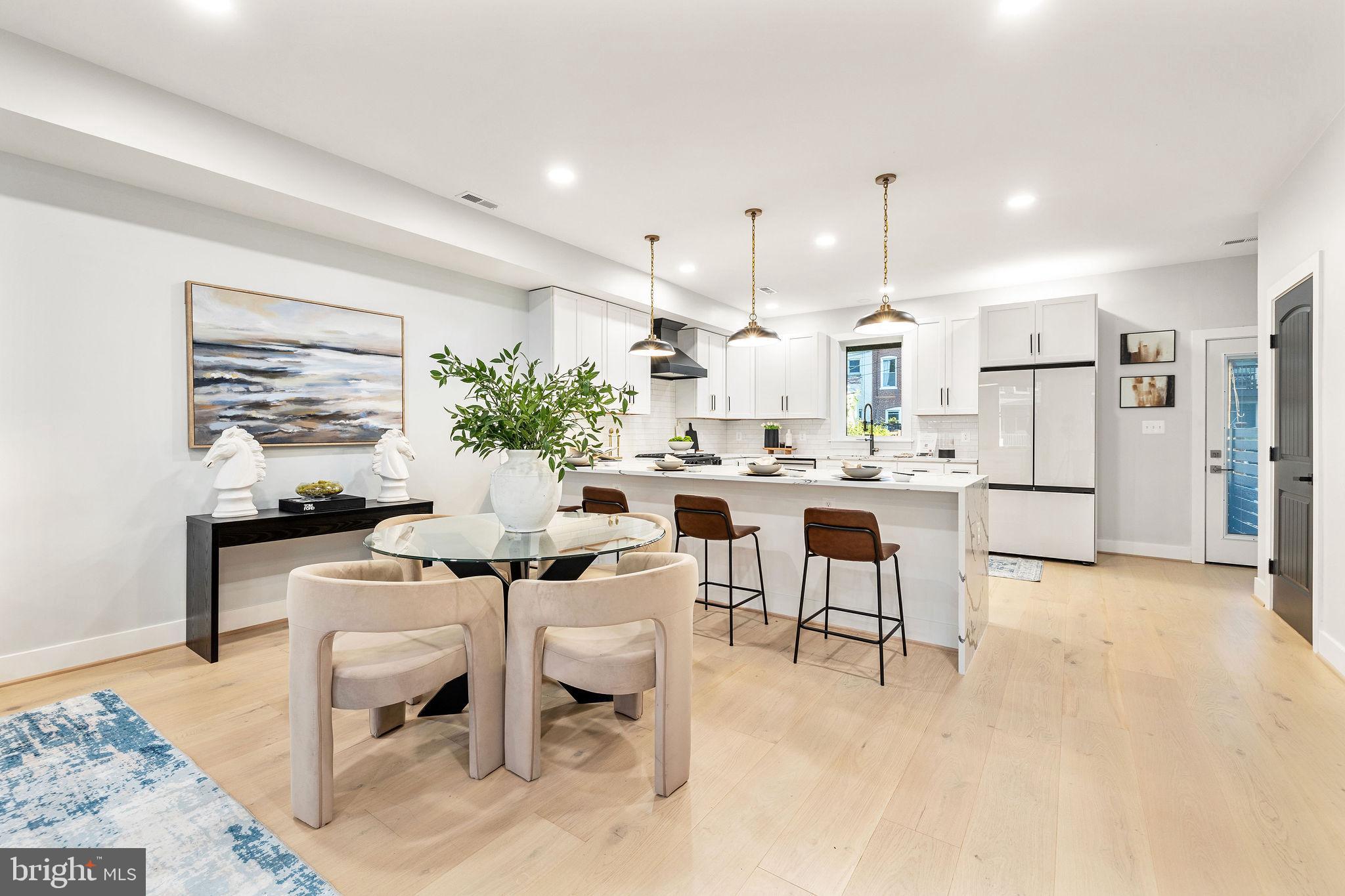 a kitchen with a dining table chairs refrigerator and cabinets