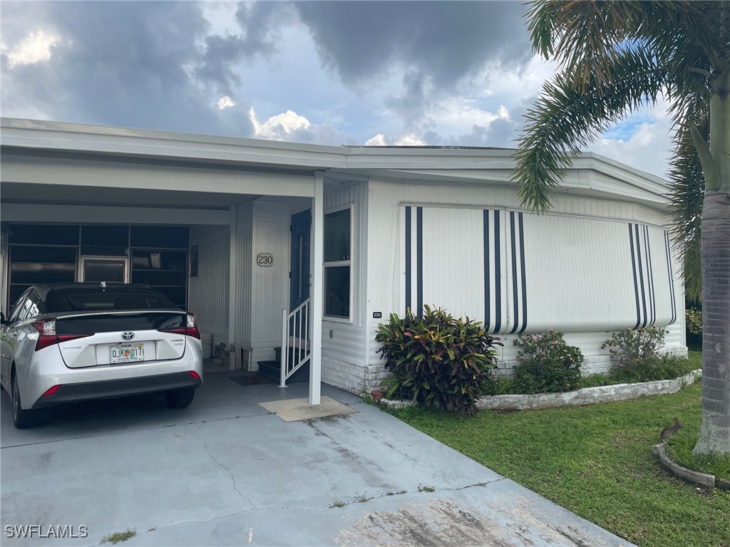 a view of a house with a cars park side of a road