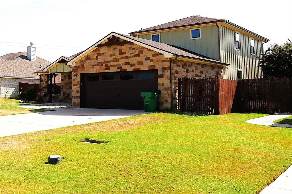 a view of a house with a yard and wooden fence