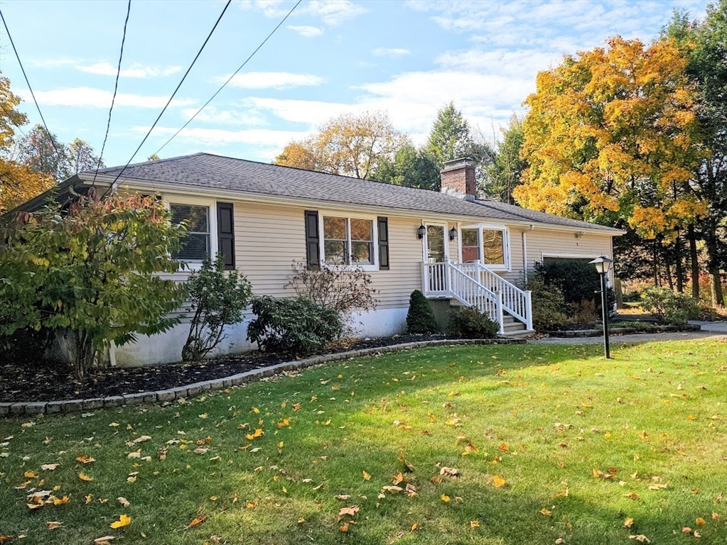 a view of a house with a yard and sitting area