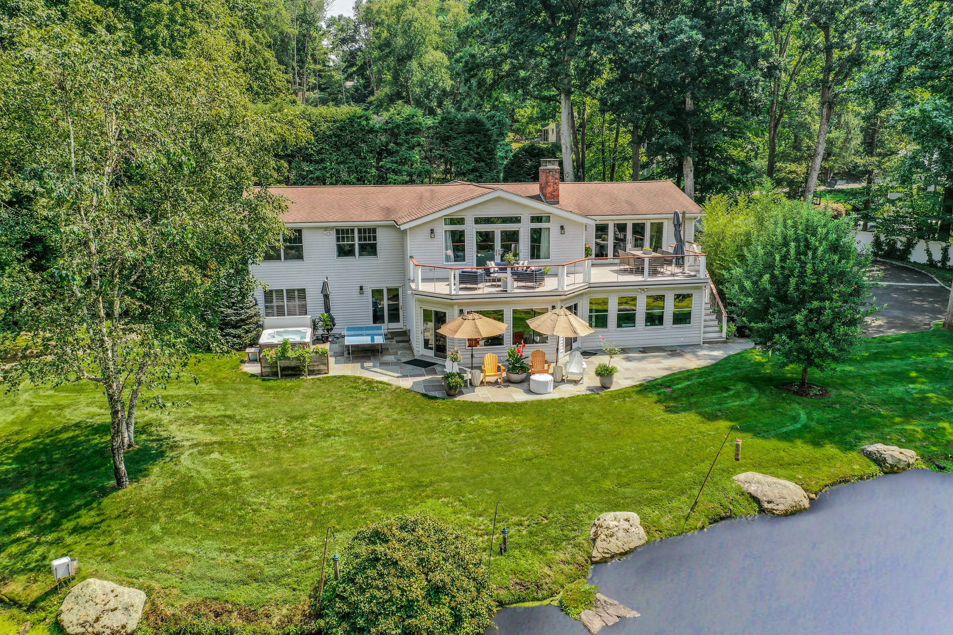 a aerial view of a house with swimming pool next to a big yard