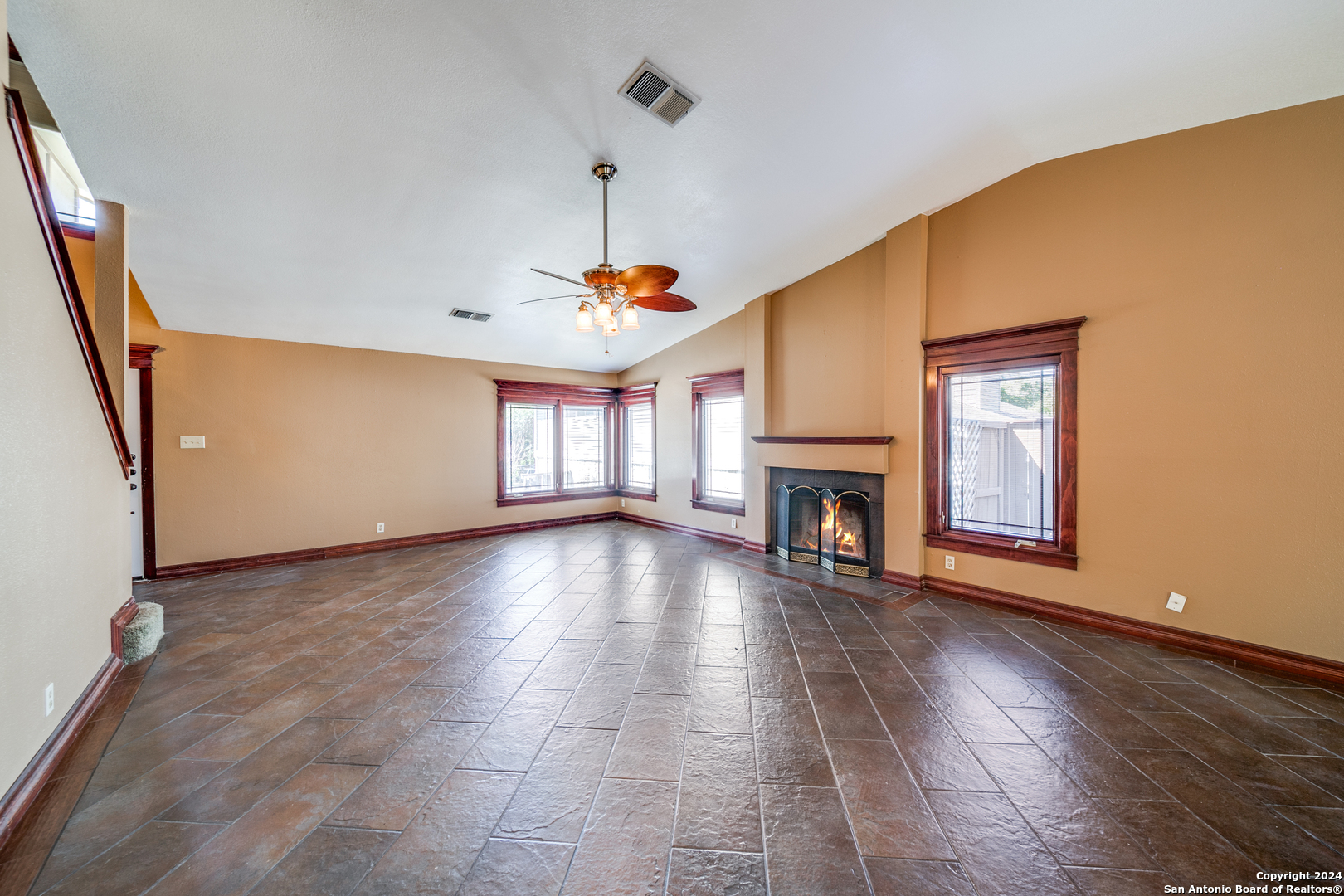 a view of empty room with fireplace and wooden floor