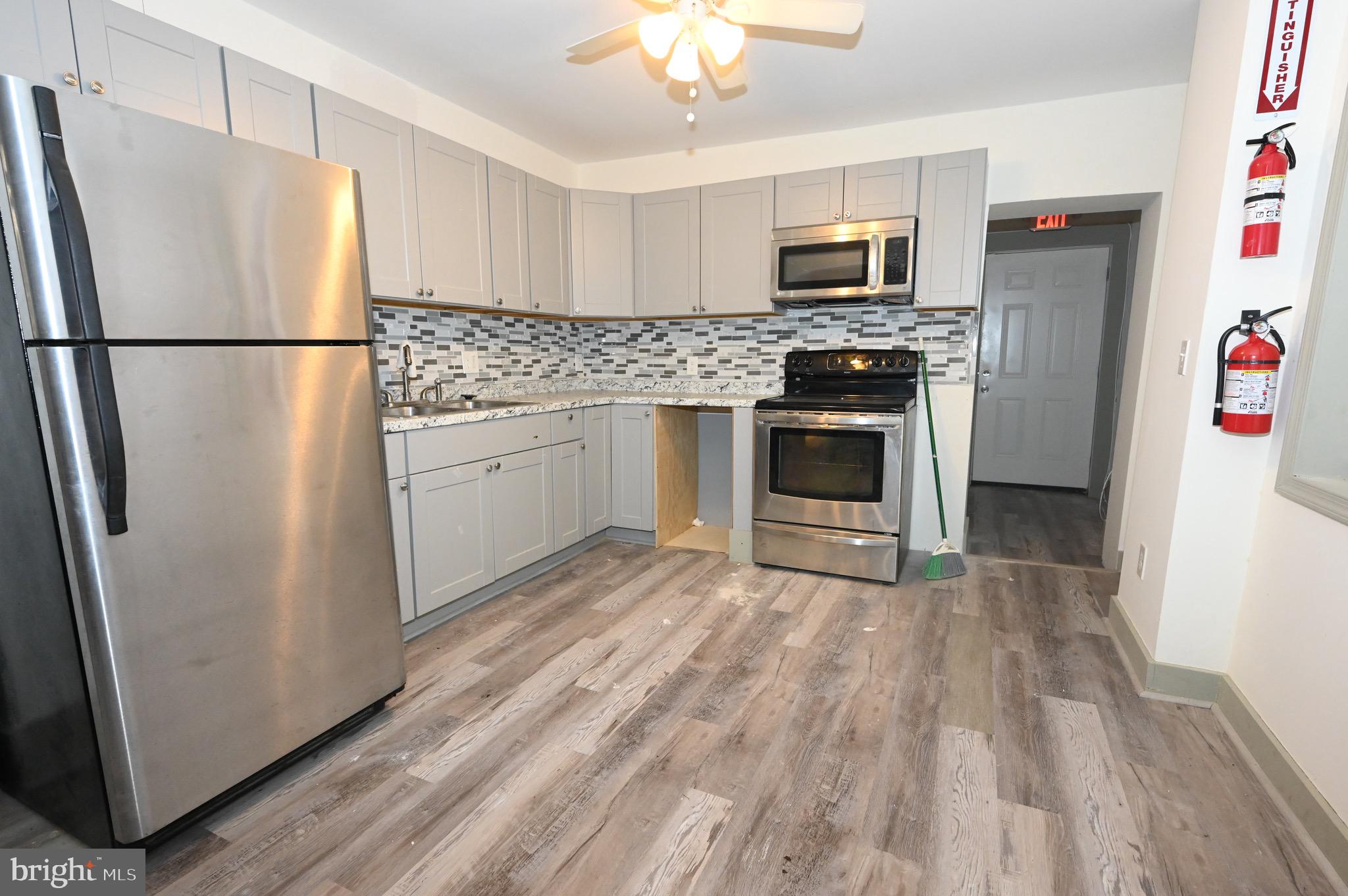 a kitchen with granite countertop a refrigerator stove and microwave