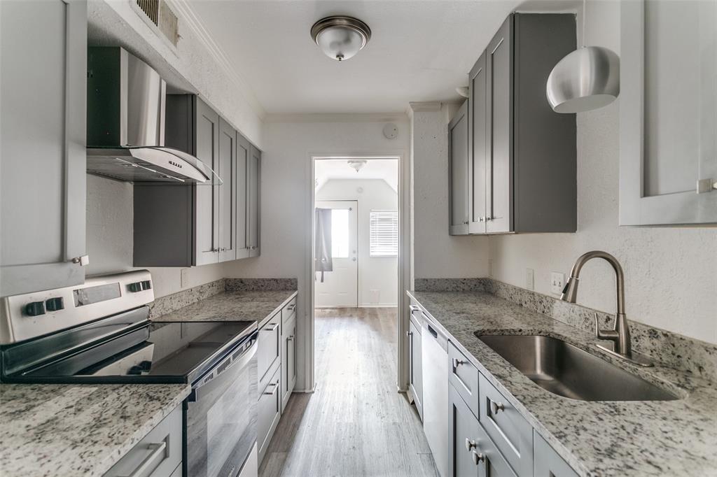 a kitchen with granite countertop a stove sink and cabinets