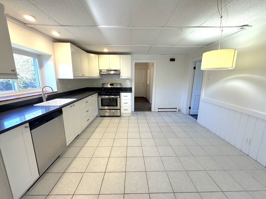 a large white kitchen with a sink a stove and a window