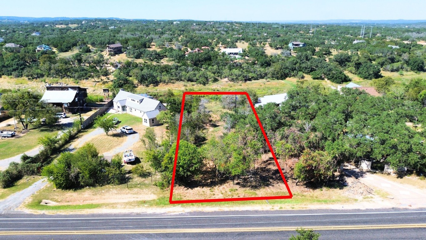 an aerial view of a house with a yard and lake view