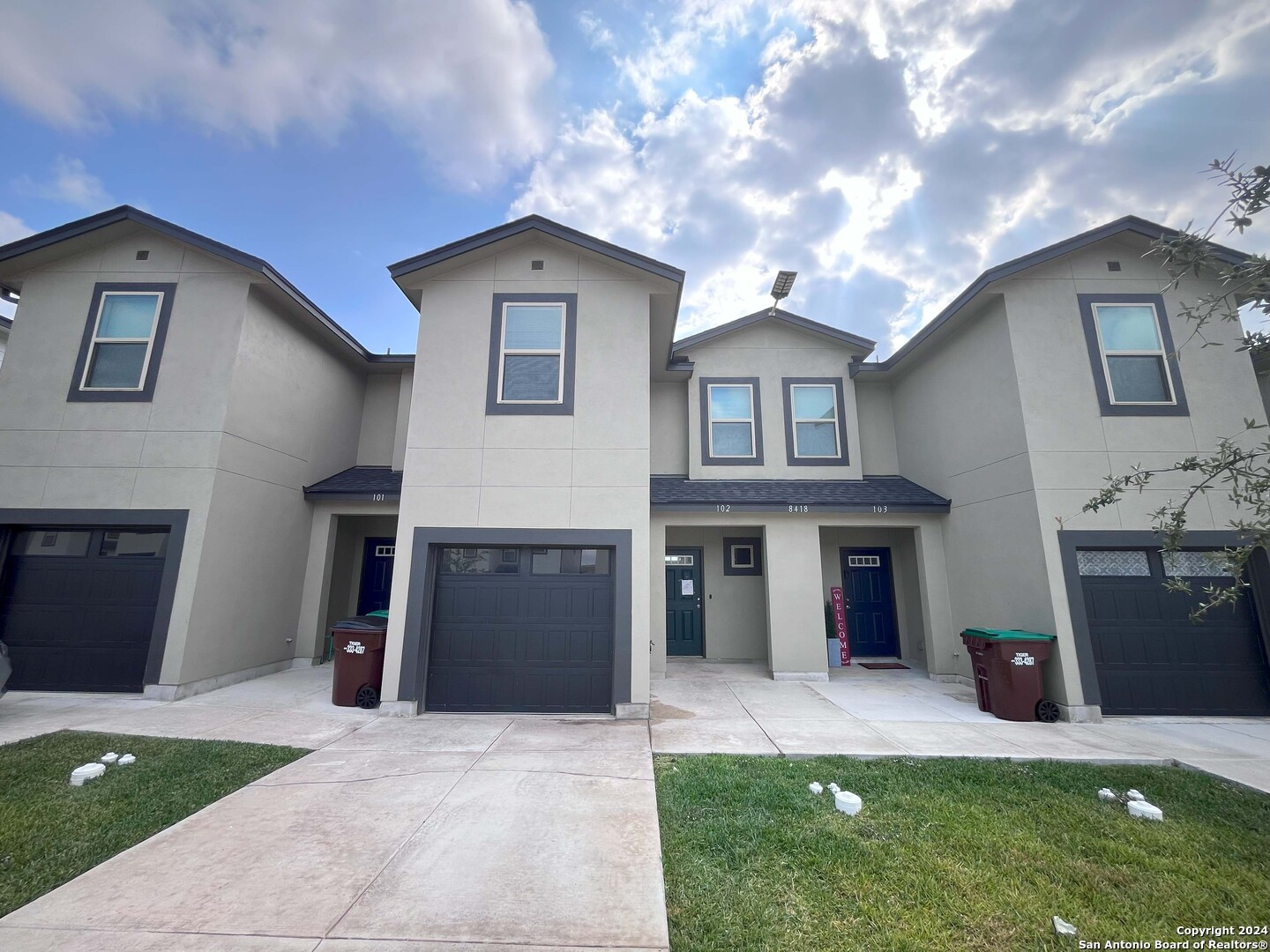 a front view of a house with a yard and a garage