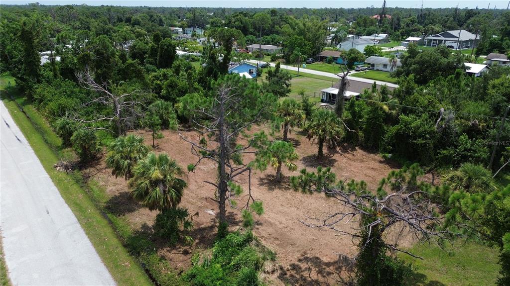 an aerial view of residential houses with outdoor space and trees