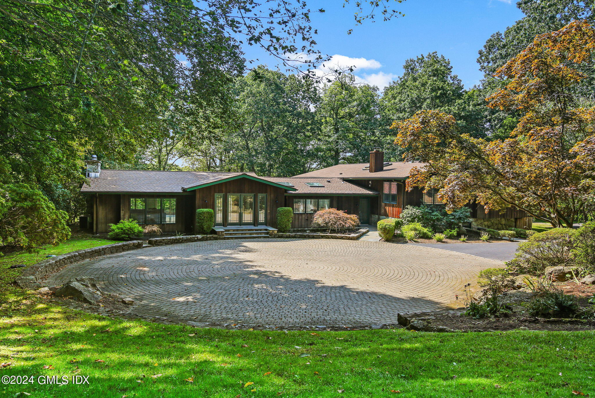 a front view of a house with a yard and trees