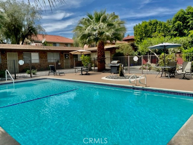 a view of a swimming pool with a table and chairs under an umbrella