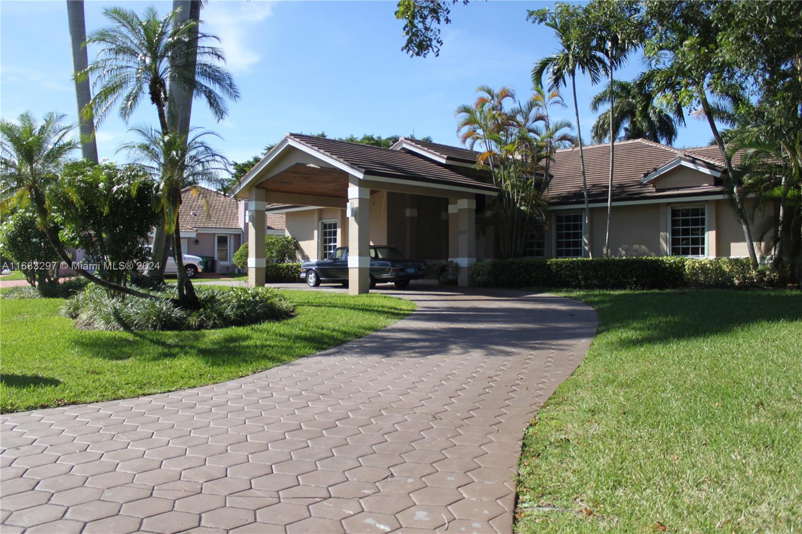 a front view of a house with a yard and potted plants