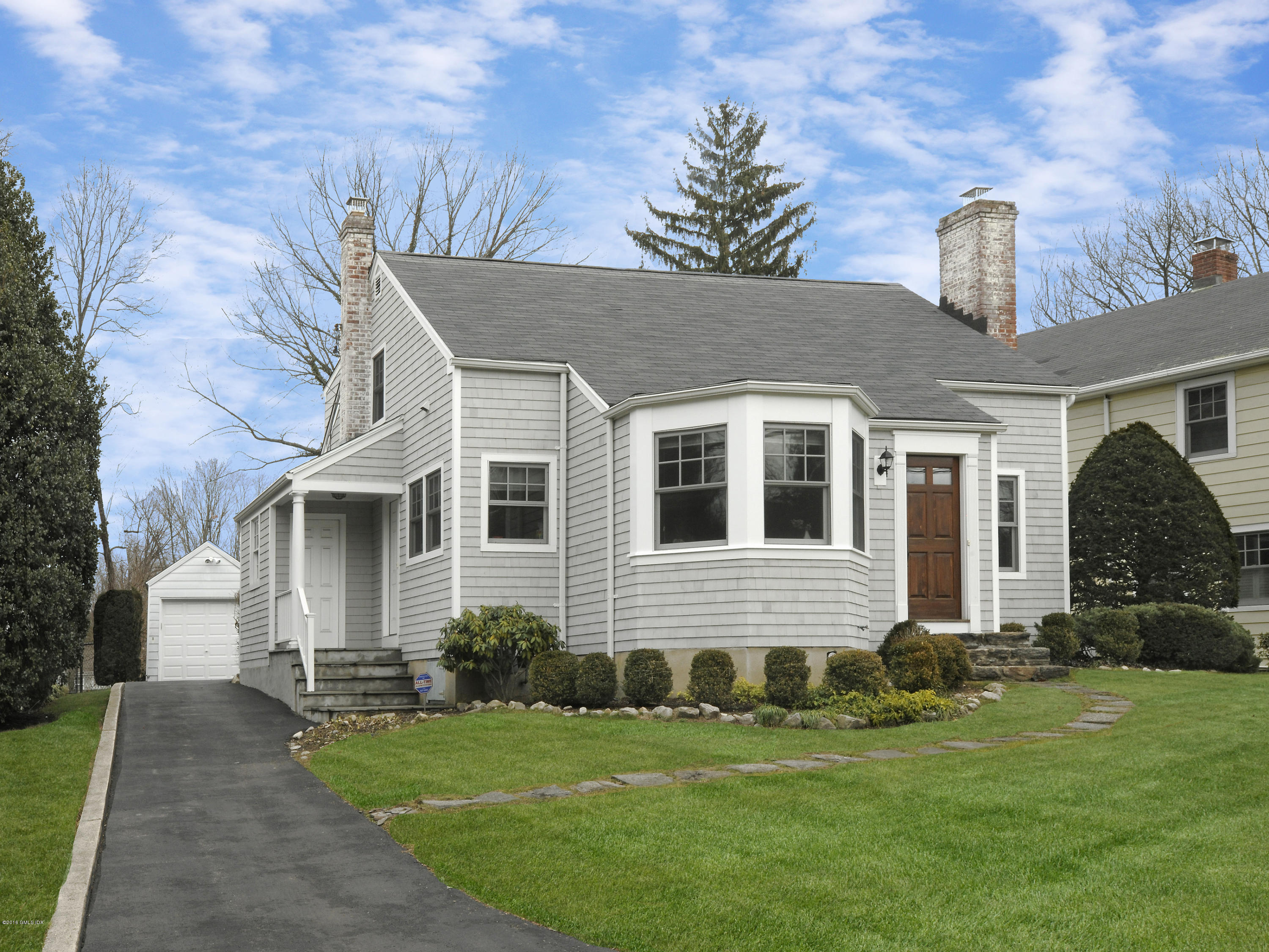 a front view of a house with a garden