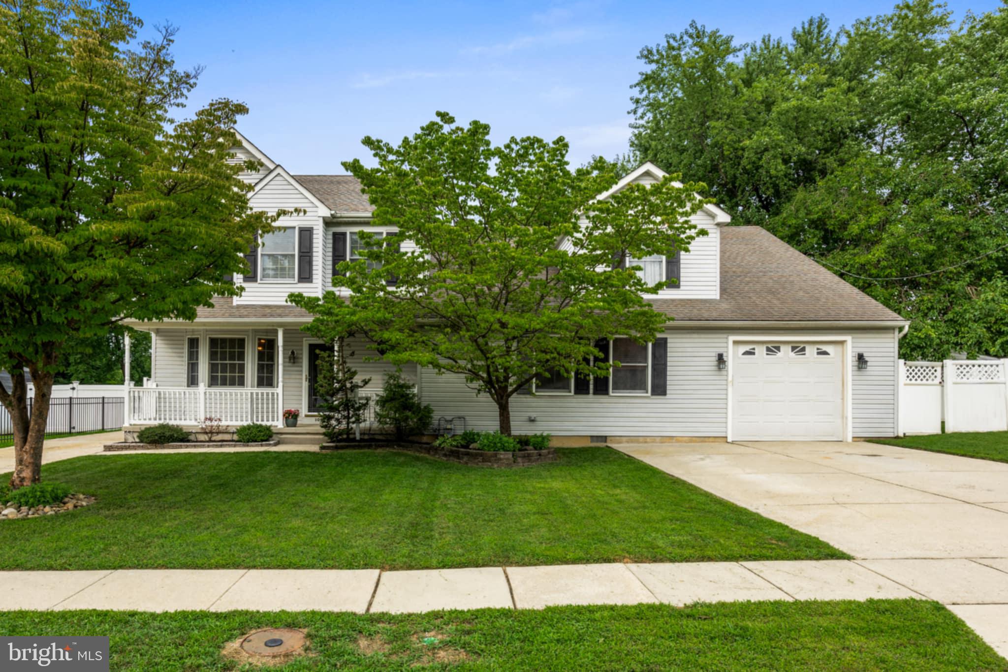 a front view of a house with a yard and trees