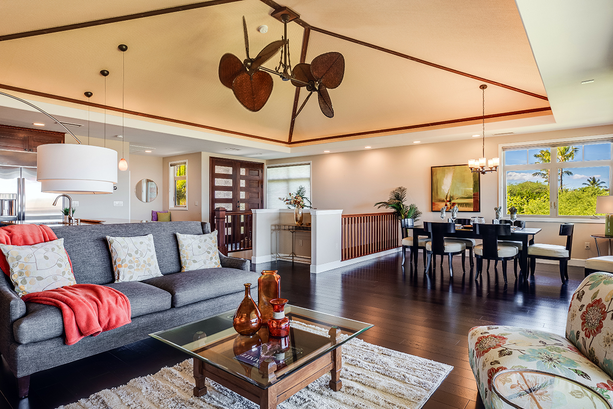 The inviting great room with vaulted ceiling, dramatic 
ceiling fan and grand staircase