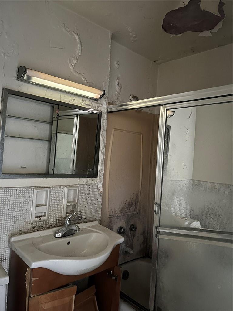 Bathroom featuring tile walls, backsplash, and vanity