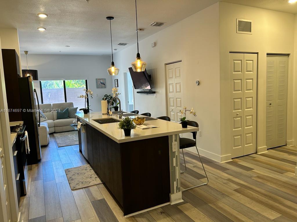 a kitchen with a sink stainless steel appliances a counter top space and cabinets