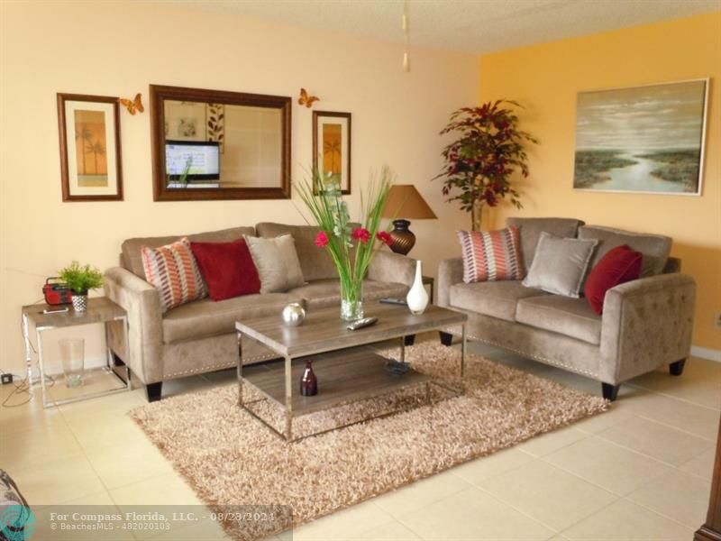 a living room with furniture and a potted plant