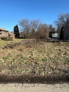 a view of a yard with wooden fence