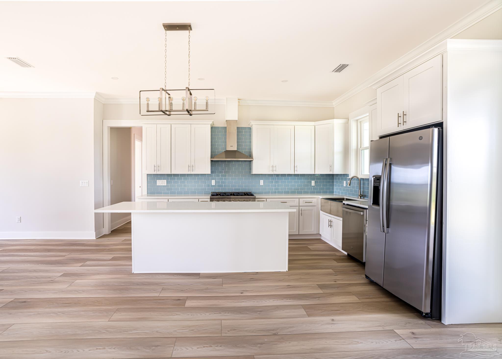 a kitchen with kitchen island white cabinets and stainless steel appliances