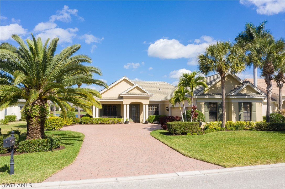 a front view of a house with a yard and potted plants