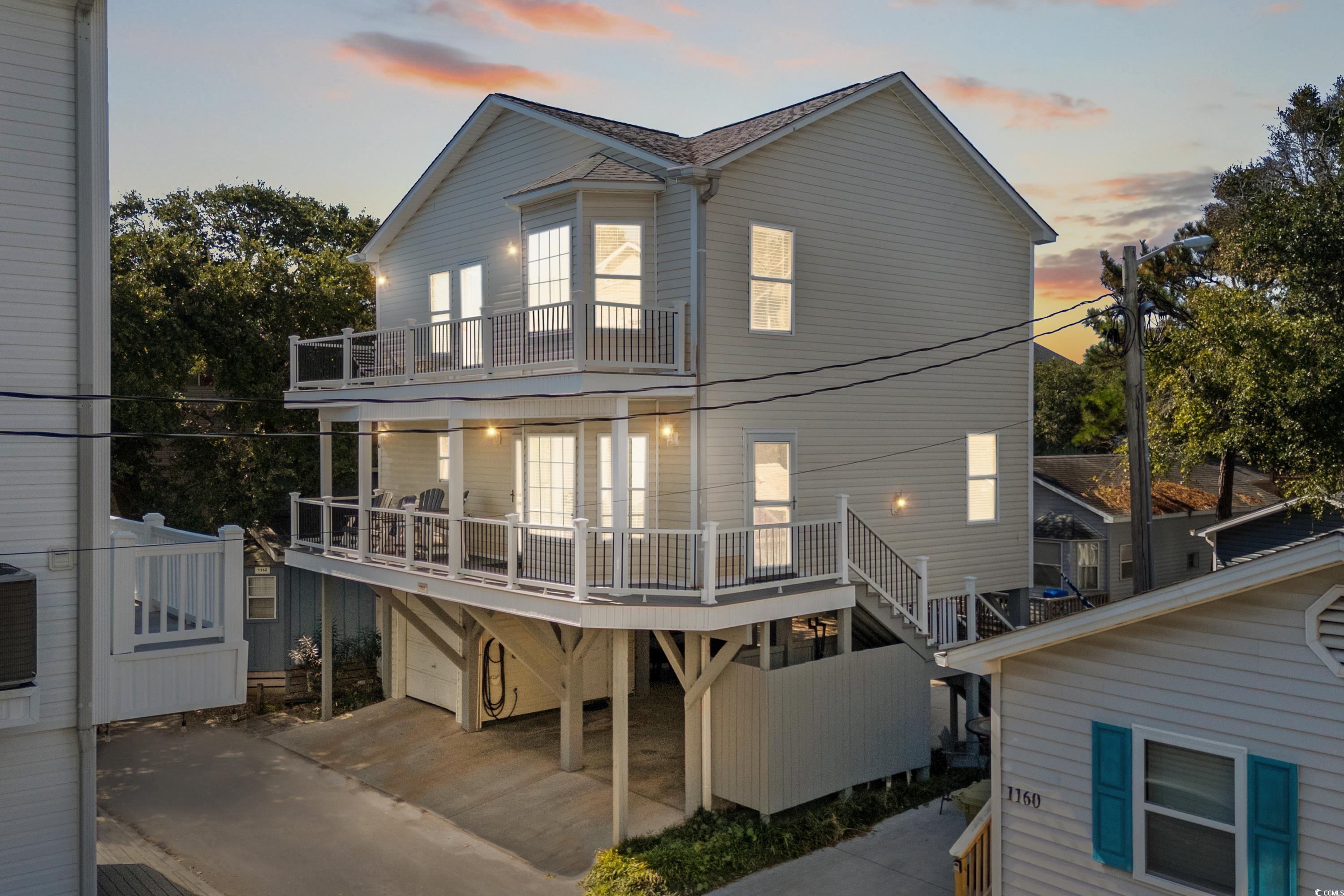 Back house at dusk with a balcony