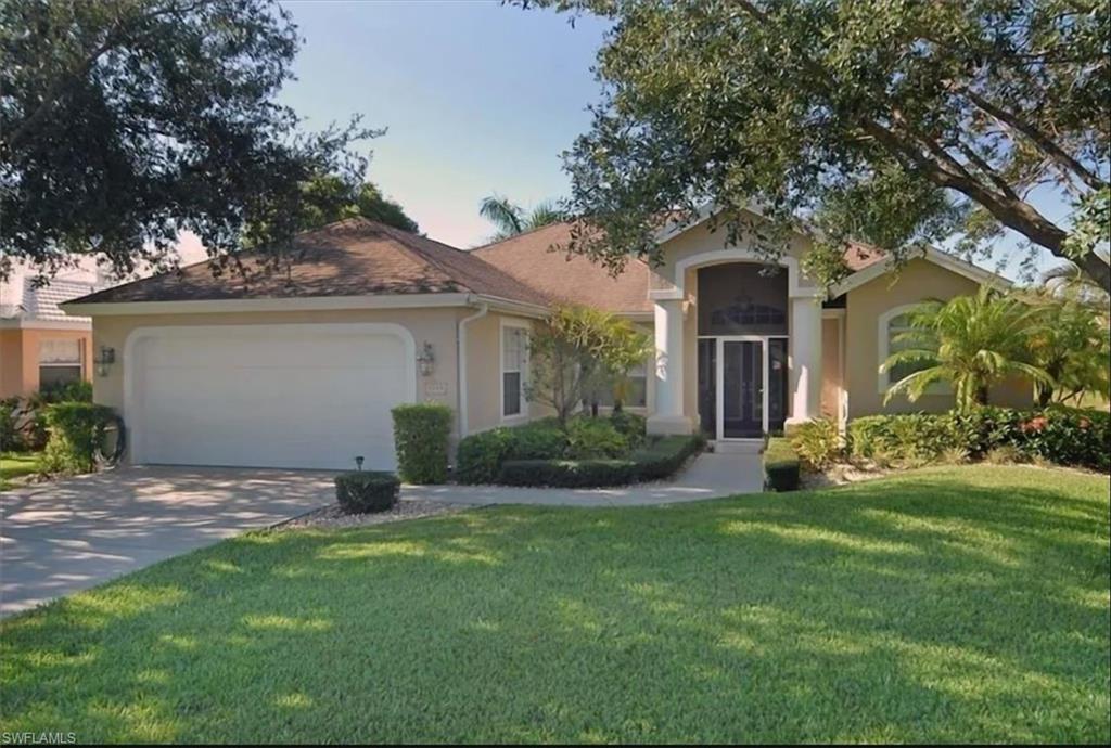 View of front facade featuring a garage and a front lawn