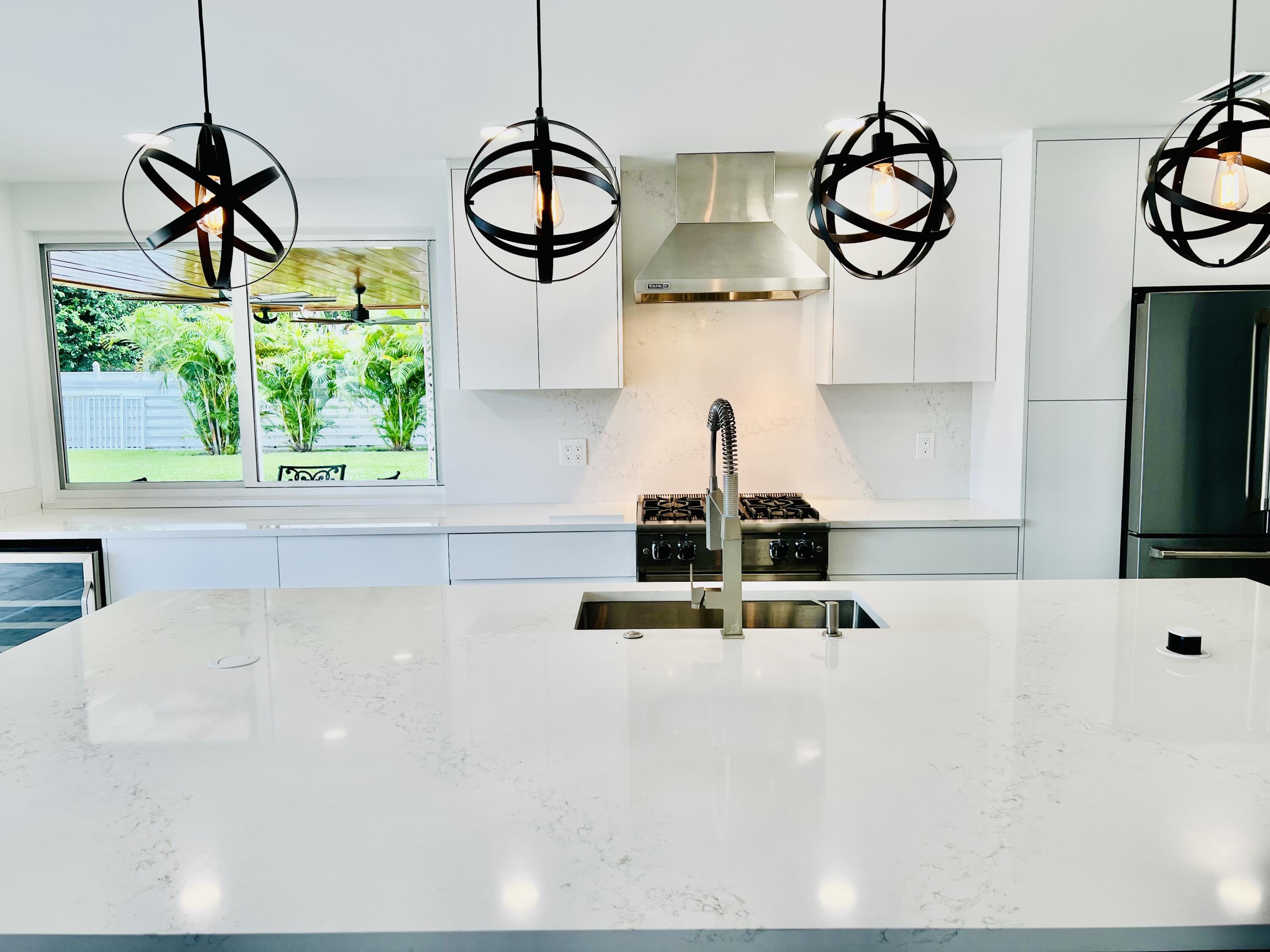 a kitchen with a large window appliances and cabinets