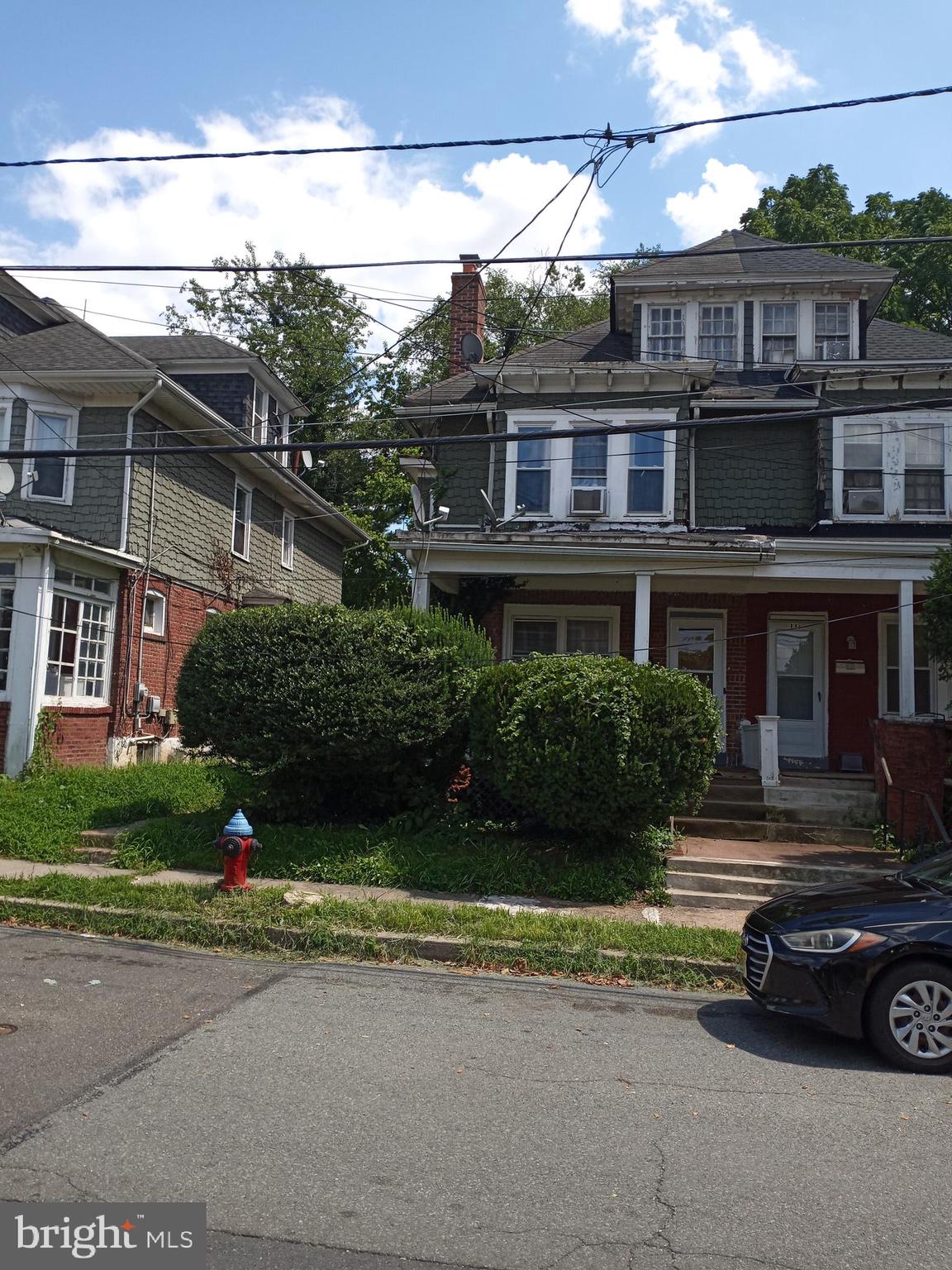 a view of a brick house with a yard and plants