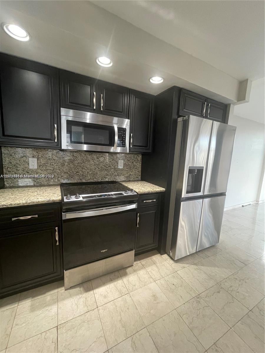 a kitchen with stainless steel appliances granite countertop a refrigerator and a sink